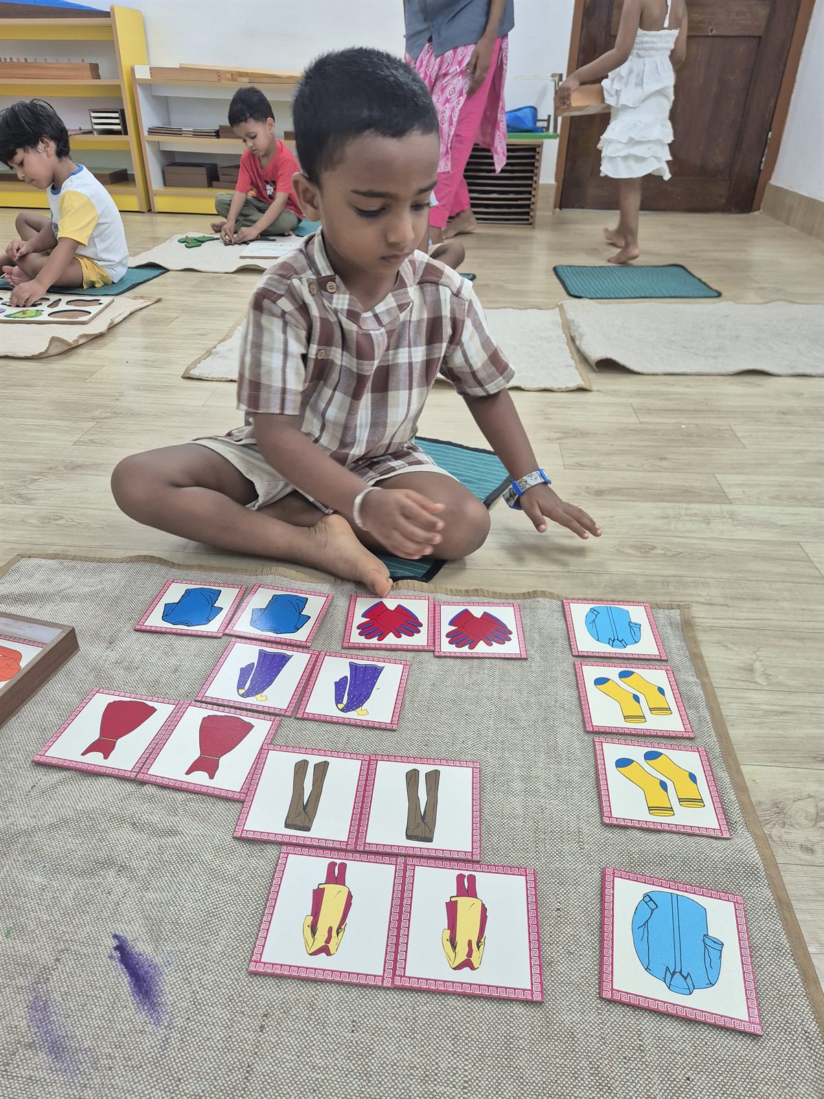 Child matching picture cards on a mat