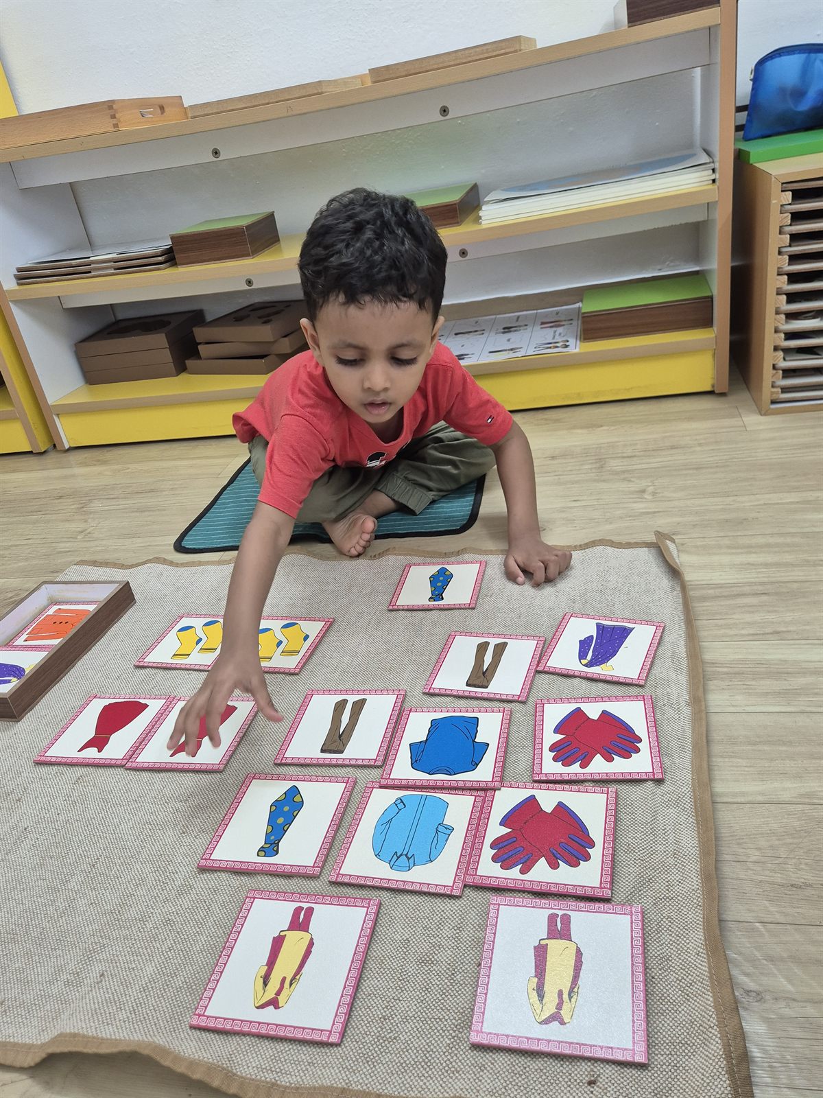 Child arranging picture and word cards on a work mat