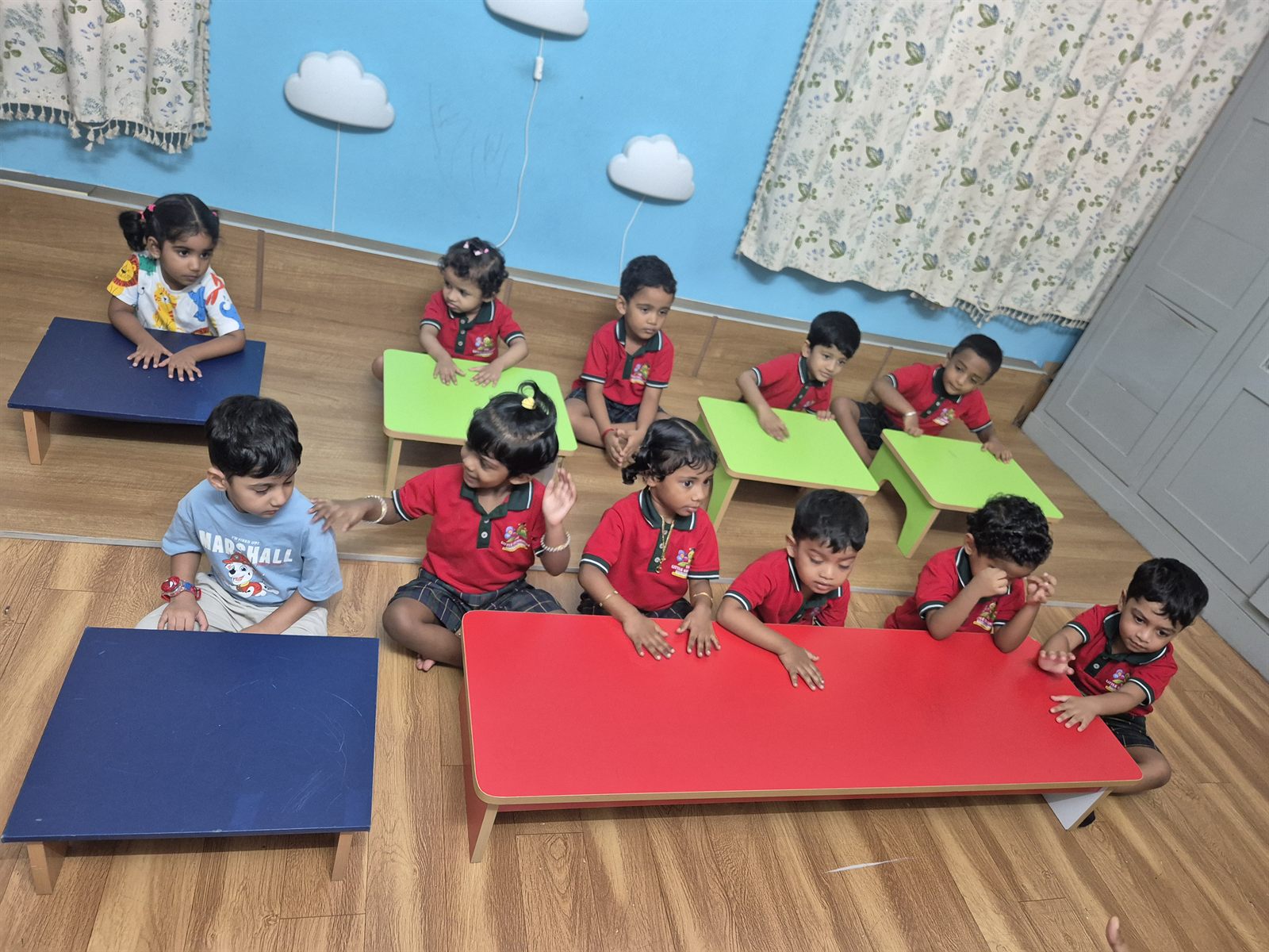Toddlers on colourful floor mats